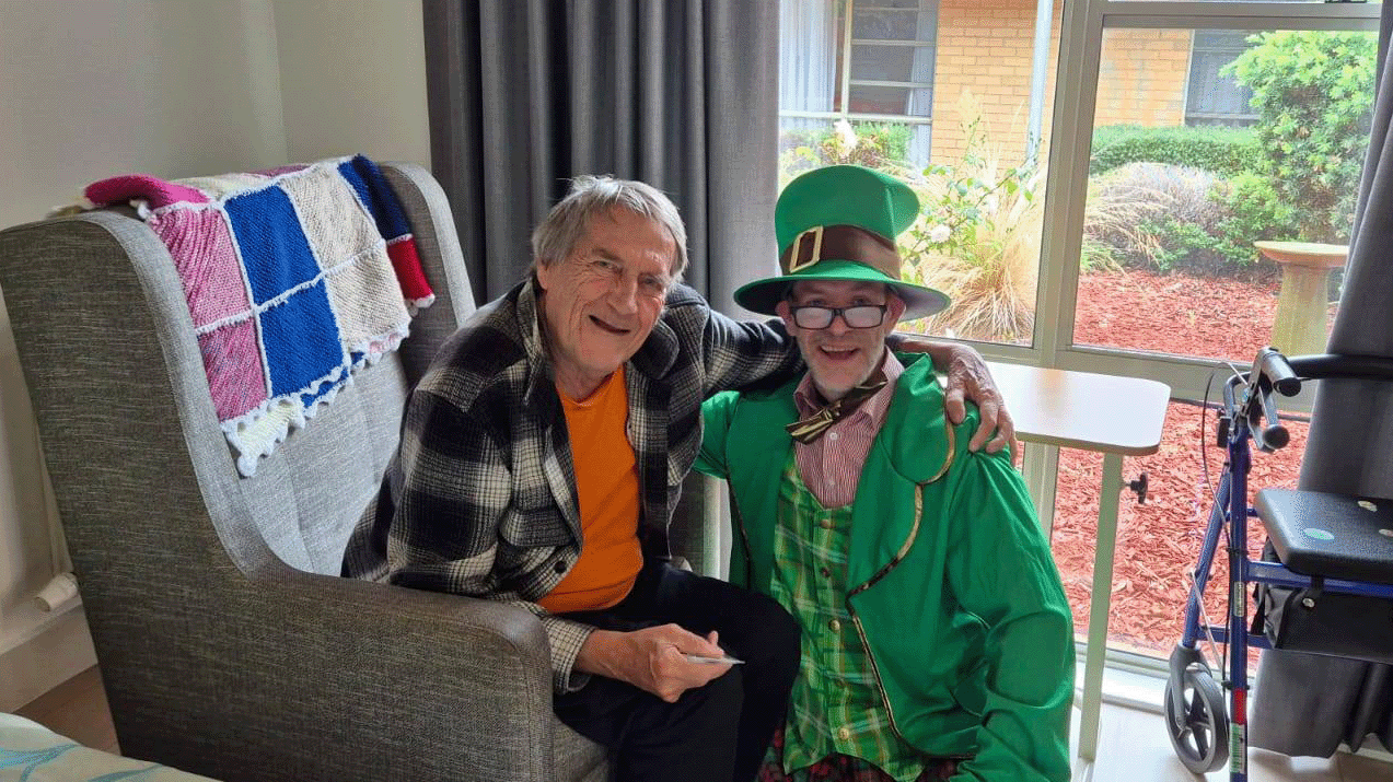 Two smiling men, one is dressed in St Patrick's Day costume