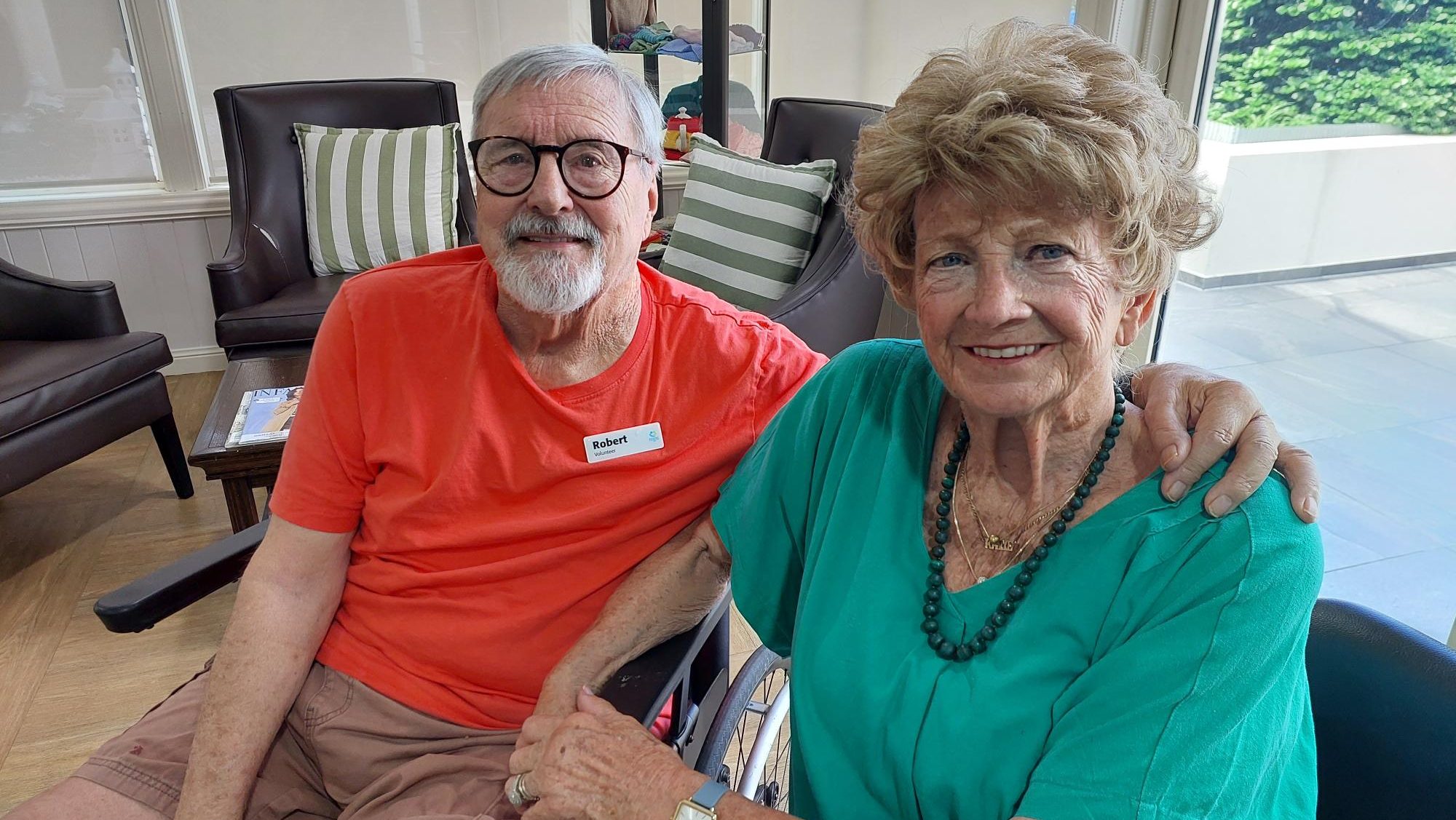 A smiling elderly couple sitting